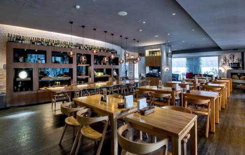 新竹卡尔登饭店 the Carlton的一间带木桌椅的餐厅和一间酒吧