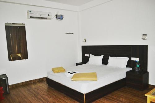 哈夫洛克岛Crossbill Beach Resort的一间卧室配有带白色床单和黄色枕头的床。