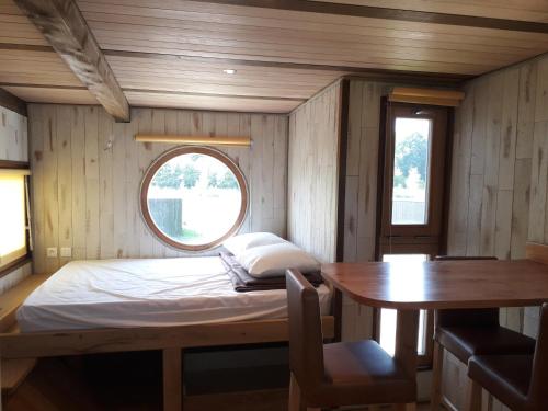 Xertigny乐斯沃迪度假屋的小房间设有一张床和一张桌子