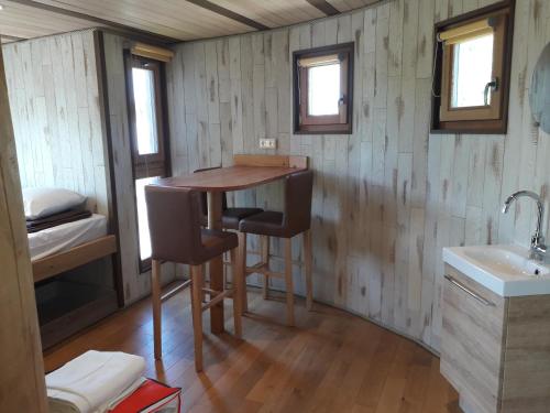 Xertigny乐斯沃迪度假屋的一间小房子里的厨房,配有桌子和两把椅子