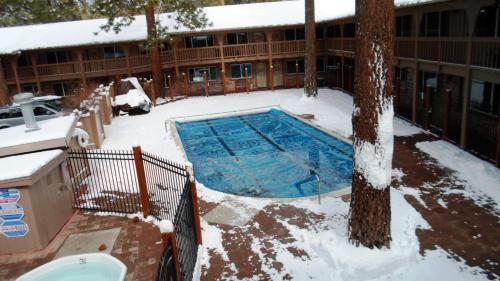 南太浩湖The Lodge at Lake Tahoe, a VRI resort的一座建筑物前的积雪覆盖的游泳池