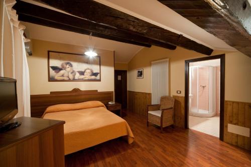 圣马力诺赫斯塔里亚达利诺酒店的一间卧室配有一张床、一台电视和一把椅子