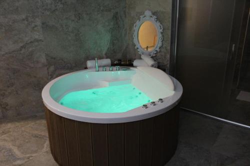 TutinIdeal city的浴室配有充满蓝色水的浴缸。