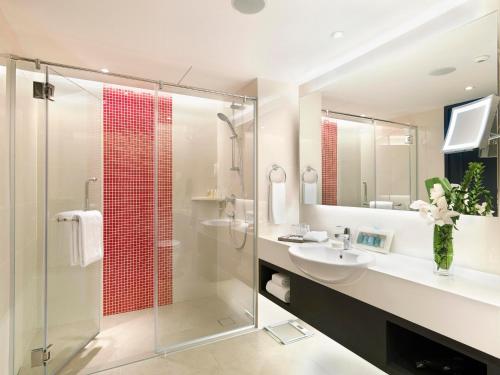 雪邦萨马萨玛克利亚酒店的一间带玻璃淋浴和水槽的浴室