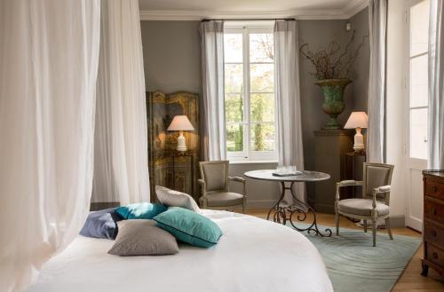 阿维尼翁神圣喜剧豪华套房旅馆的一间卧室配有一张床、一张桌子和一个窗户。