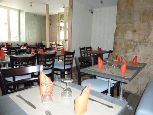 拉苏特兰A La Porte Saint Jean的用餐室配有桌椅和橙色餐巾