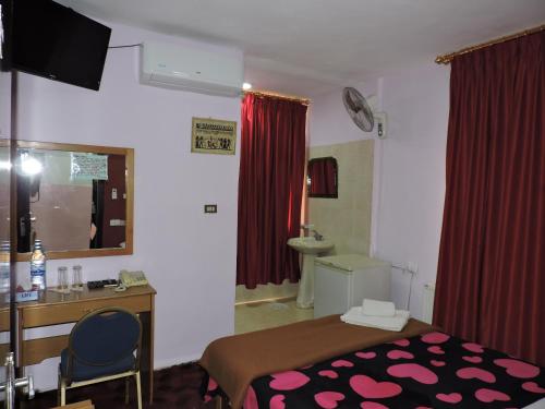瓦迪穆萨情人节旅馆的一间卧室配有一张床、一张桌子和一个水槽