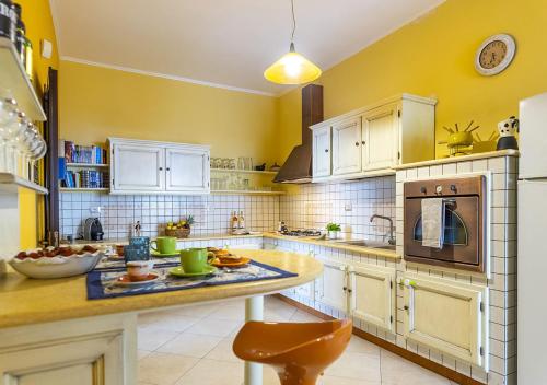 玛丽娜迪曼卡维萨Dimora Smeraldo的一间设有黄色墙壁和白色橱柜的大厨房