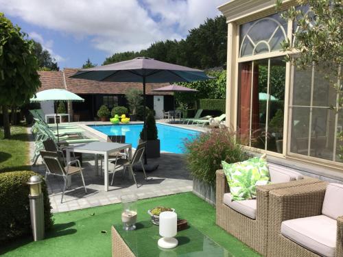 DudzeleBoutique hotel Het Bloemenhof的后院设有游泳池、桌子和椅子