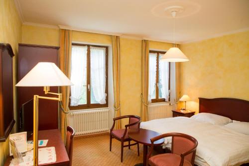 布洛奈巴希瑟酒店的酒店客房带一张床、一张桌子和椅子