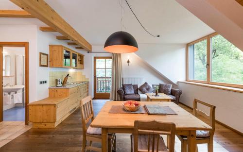 坎波图雷斯梅尔祖霍夫自然公寓酒店的厨房以及带木桌的起居室。