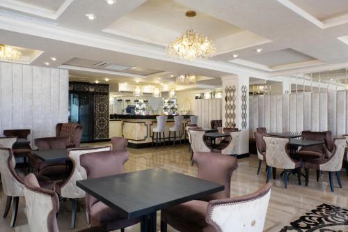 阿德勒Tropicana Resort Hotel Sochi的一间带桌椅的餐厅和一间酒吧