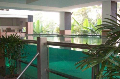 曼谷拉查达17普拉斯酒店的一座绿色的游泳池,位于一座建筑中