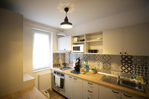 蒂米什瓦拉SMP apartment 3的厨房配有白色橱柜、水槽和窗户。