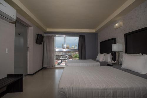 奥里萨巴哈酒店的酒店客房设有两张床和大窗户。