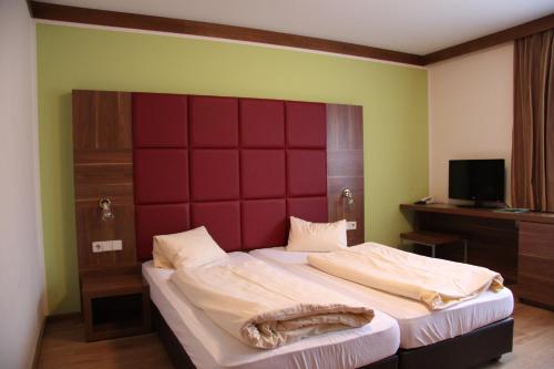 弗拉塔赫莫塔尔运动酒店的一间卧室配有一张大床和红色床头板