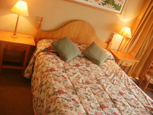 普孔La Peninsula Rehue的一张位于酒店客房的床位,配有两张桌子和两盏灯