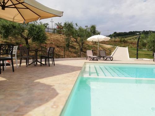 科隆内拉Country House Ciliegia Rossa的一个带桌椅和遮阳伞的游泳池