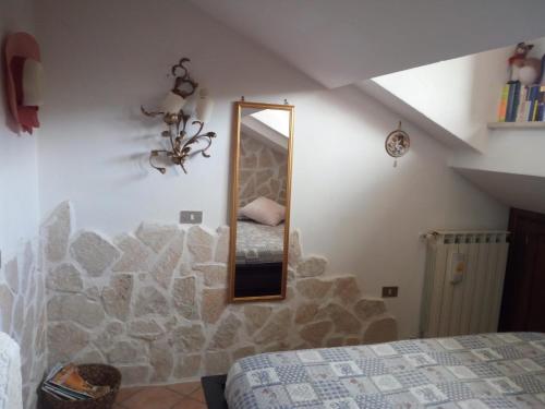 佩斯卡塞罗利Casa Coccorico' Pescasseroli的一间卧室配有带镜子的石墙