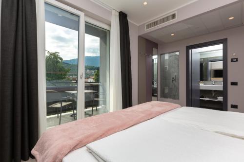 加尔达湖滨Garda Life的一间卧室设有一张床和一个大窗户