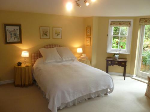 切尔滕纳姆Laurel House的卧室配有一张白色大床和两个窗户