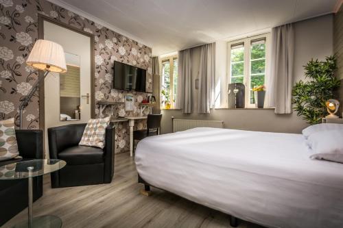 HulsbergCarré Hotel Zuid-Limburg的酒店客房带一张大床和一把椅子