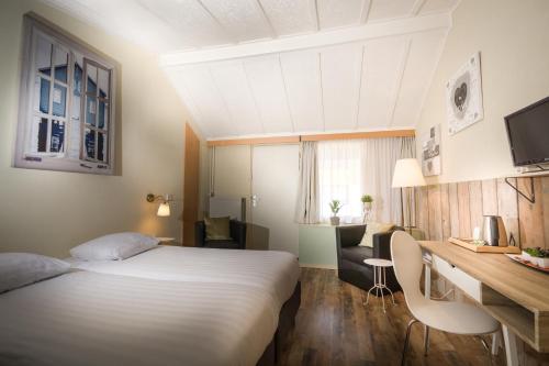 HulsbergCarré Hotel Zuid-Limburg的配有一张床和一张书桌的酒店客房