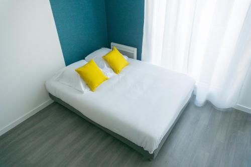 维勒班特BtoBed - 巴黎北维勒班特公寓的一张床上有两个黄色枕头的房间