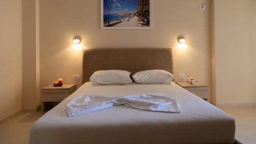 都拉斯Villa Balani的一间卧室配有一张带两张蜡烛的床。