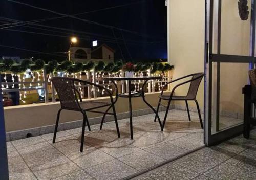 皮乌拉Hotel Calmelia的晚上阳台上配有两把椅子和一张桌子