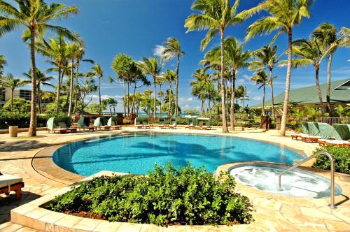 卡胡库Ocean Villas at Turtle Bay的度假村内一座带棕榈树和椅子的游泳池