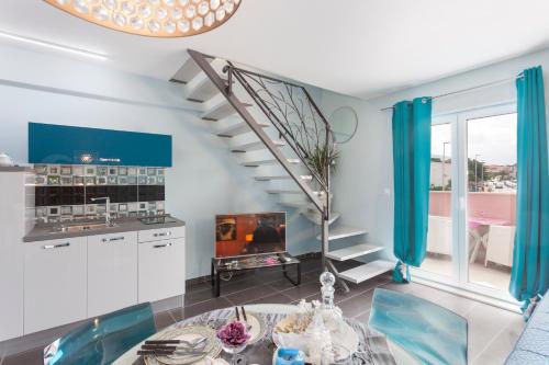 马卡尔斯卡Luxury Apartments Marhella & Jakov的客厅设有螺旋楼梯和桌子