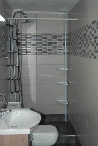 内亚卡瓦里Soula's Sunshine Apartments的带淋浴、卫生间和盥洗盆的浴室