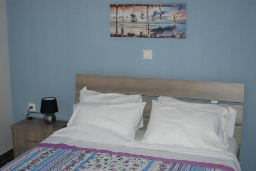 内亚卡瓦里Soula's Sunshine Apartments的一张带白色床单和枕头的床