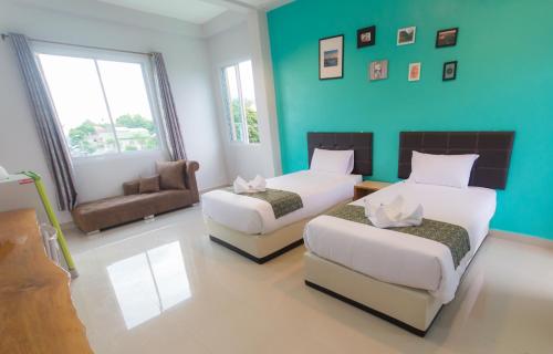 乌汶乌汶佳地公寓的酒店客房,设有两张床和一张沙发