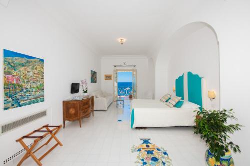 波西塔诺爱赛昂公寓式酒店的一间白色的房间,配有床和客厅