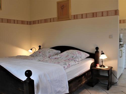TarnewitzSpacious Apartment in Boltenhagen with Garden的一间卧室配有一张带白色床单和两盏灯的床。
