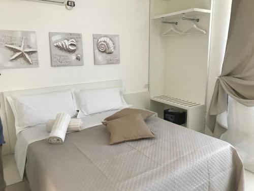 罗迪-加尔加尼科Villa Vittoria City的白色卧室,配有带毛巾的床