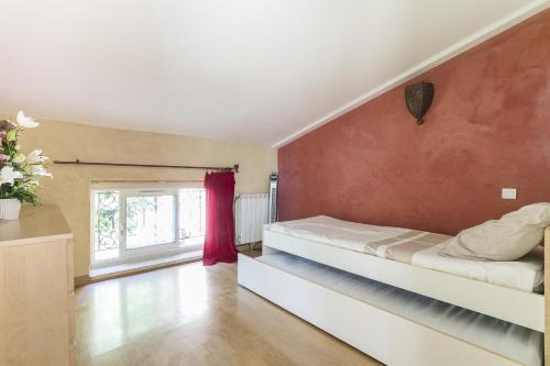 迈兹Domaine Sesquier Mas d'exception Acacia的一间卧室设有一张床和红色的墙壁