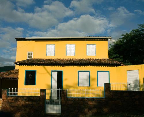 伦索伊斯Pôr do Sol Suítes的前面有栅栏的黄色房子