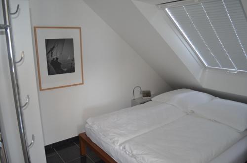 黑尔戈兰岛Dünenblick Apartments的窗户客房内的一张白色床