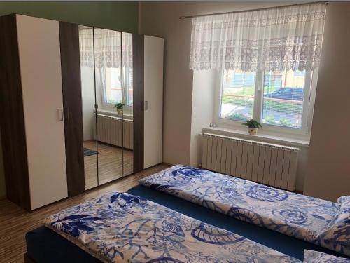 波斯托伊纳Apartma Mahnič的一间卧室设有两张床和大窗户