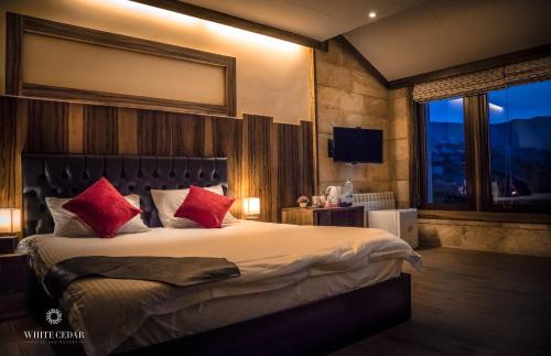 阿尔·阿尔兹白雪松度假酒店的一间卧室配有一张带红色枕头的大床