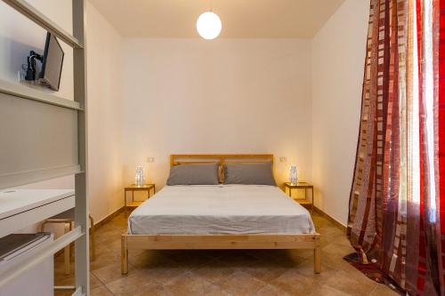 米内尔维诺迪莱切Il Giardino di Jo的一间卧室配有床和两张边桌