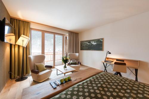 朗根费尔德四星级水族圆顶高级酒店的酒店客房设有一张大床和一张书桌。