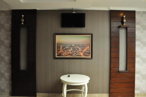 美娜多Casa de Wanea Hotel的墙上挂着照片的房间的桌子和凳子