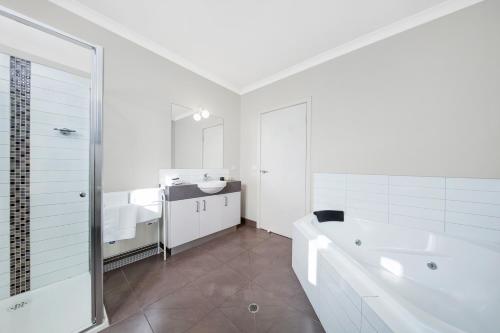 莱伊月光湾公寓 的白色的浴室设有浴缸和水槽。