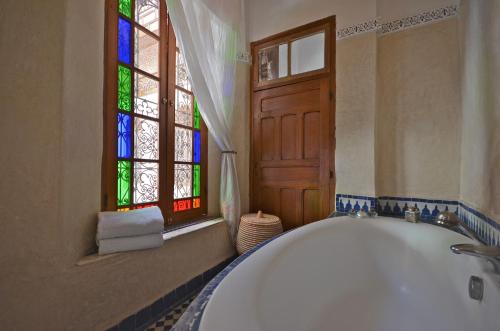非斯达尔罗马那旅馆的带浴缸的浴室和彩色玻璃窗