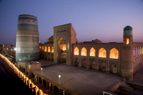 希瓦Orient Star Khiva Hotel- Madrasah Muhammad Aminkhan 1855的一座清真寺和一座尖塔的建筑的景色