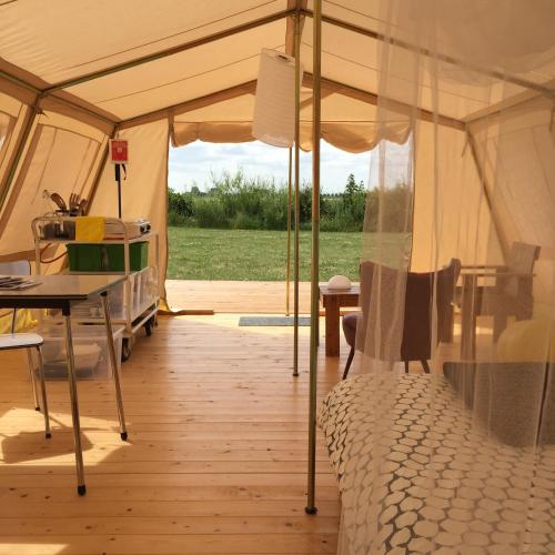 赫鲁德VierVaart Tent的帐篷配有一张床和一张桌子